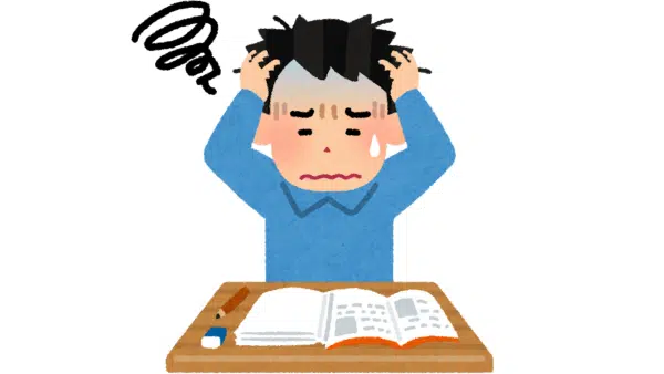 A man sits at a desk, resting his head in his hands, conveying a sense of stress or frustration.